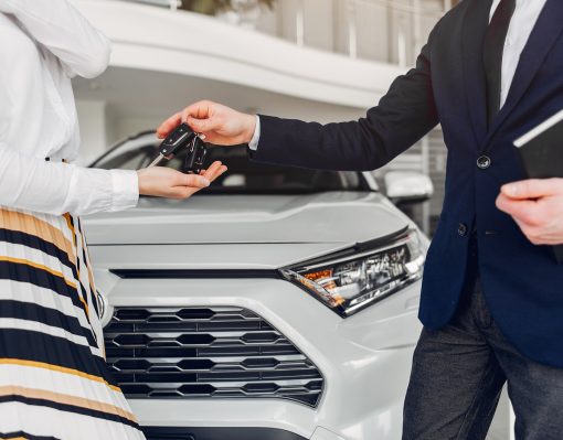 Woman buying the car. Lady in a car salon. Manager with a client